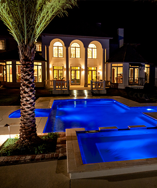 Night time view of home and pool with LED lights
