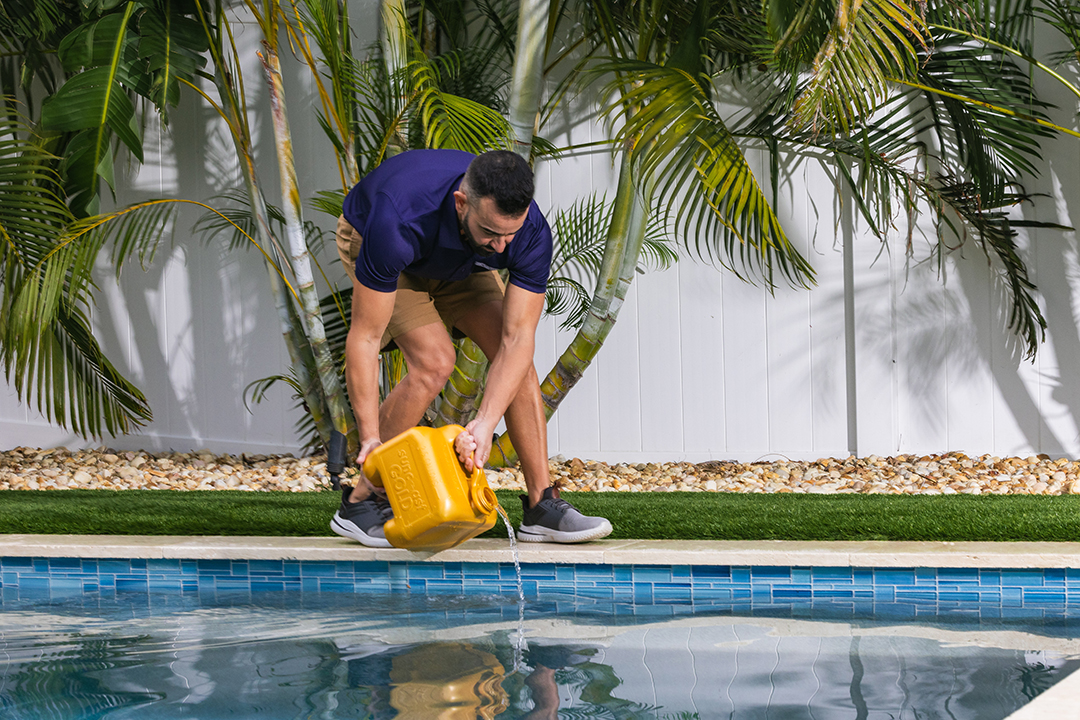 Technician chlorinating pool